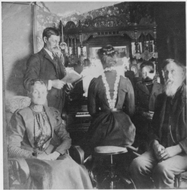 The caption on the back indicates this is Francis with Bertha at the organ and Lindsay on the right. The couple in front are unidentified. (Original: Janet Lucius)
