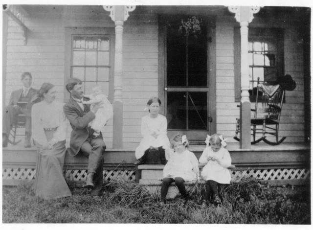 Lindsay sitting on porch, then Lucy, Francis holding June, Esther, Ruth, and Marion.  Picture taken at Benjamin and Ida Boughton's house in Bear Valley, around 1908. This picture was duplicated from the original by William Bundy circa 1960, and thus has less fading. (Original: Janet Lucius)