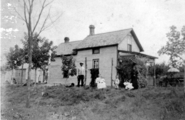 Alex standing, then Marie in rocking chair holding Elmer, Ed, Rose, and Jeanette (sister of Alex).  Taken on the family farm at Grey Cloud Island, 1897.