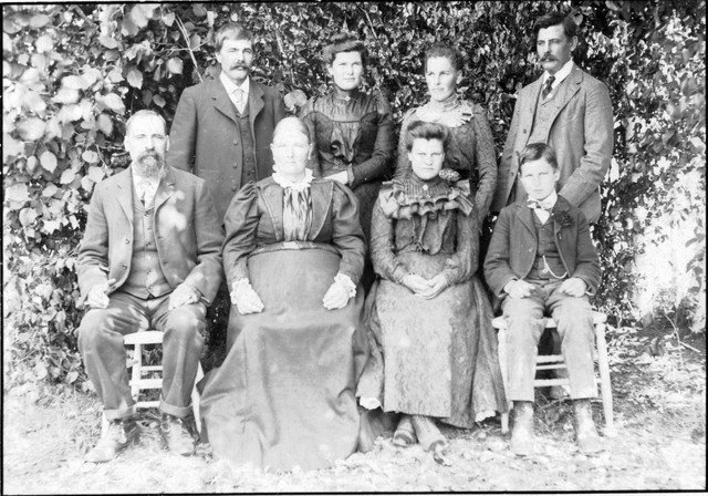 Andrew and Anna Mattson (sitting, front left) and their children. In 1900, Annie was listed as having six living children. Clara is third from left in the front row. Based on comparison with a picture postcard of "Mrs. C. Olson", the woman standing second from left is Mary. Based on the 1900 census, the two men standing are Andrew and Annie's sons, Andrew and Alfred. The youngest son must be Victor, also based on the 1900 census. Victor is known from census data and his WWI draft registration card to have lived with his sister Mary in Washington State. Bob Winberg's address book from 1930-1940 contains addresses all on one page for 1) Mrs. Bjorling (Mary Mattson; her second husband was Eric Bjorling) of Everett, Washington, 2) Victor Mattson, of Monroe Washington, and 3) a Mrs. Thomas Oline, of Tacoma, Washington, who is found listed along with Emily Mattson as the parents of Lawrence Robert Oline, born to them in King County, Washington. The Olines are found in the 1930 census of Tacoma at the same address listed in Bob Winberg's address book. So the woman in back second from right was Emily. That accounts for all six living children. Since Victor was born in 1890, the picture appears to date from around 1900. (Original: Mary Hundeby) 